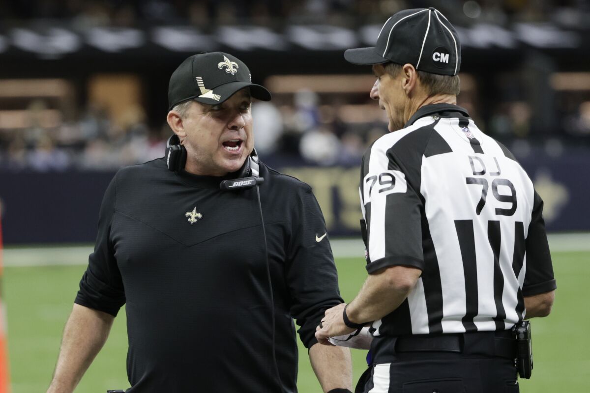 New Orleans Saints head coach Sean Payton speaks with down judge Kent Payne (79) during the second half of an NFL football game against the Dallas Cowboys, Thursday, Dec. 2, 2021, in New Orleans. (AP Photo/Derick Hingle)