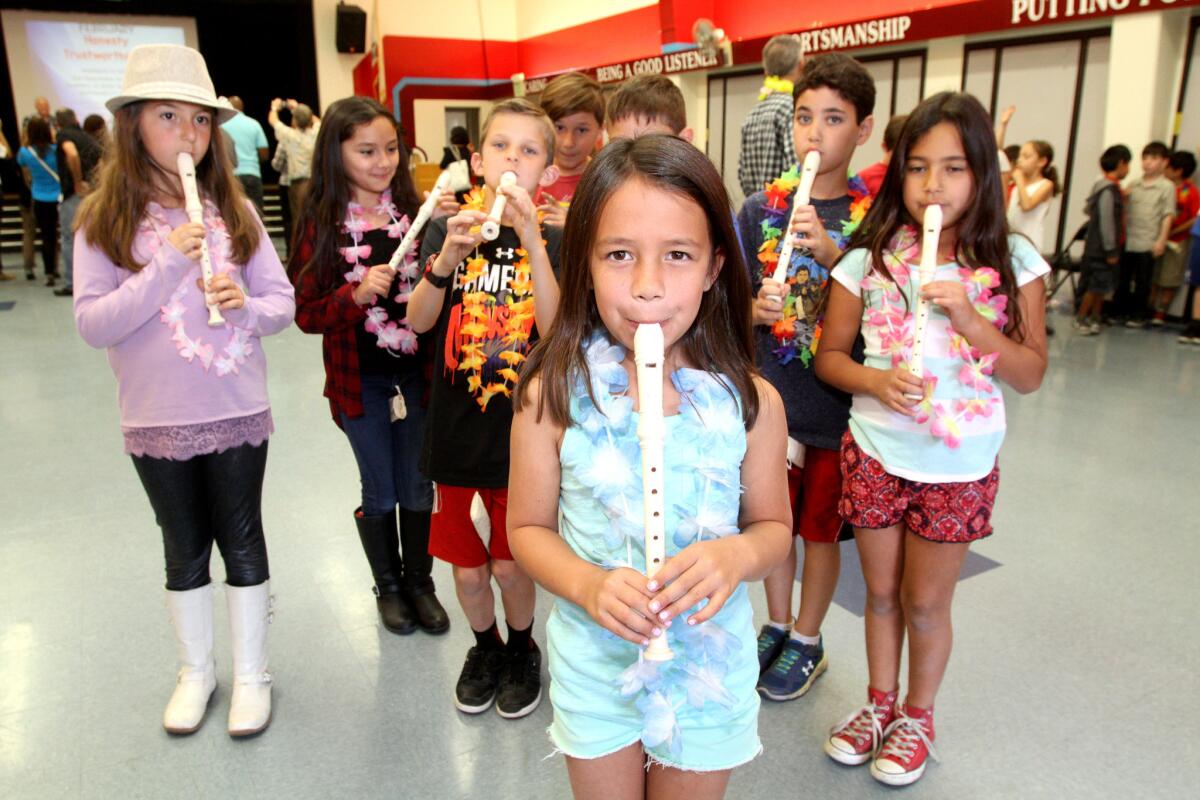 Lincoln Elementary School third grader Isabella Alonzo, front center, and fellow students musicians show how they play the recorder after the flag ceremony at the school in La Crescenta on Friday, Feb. 26, 2016.