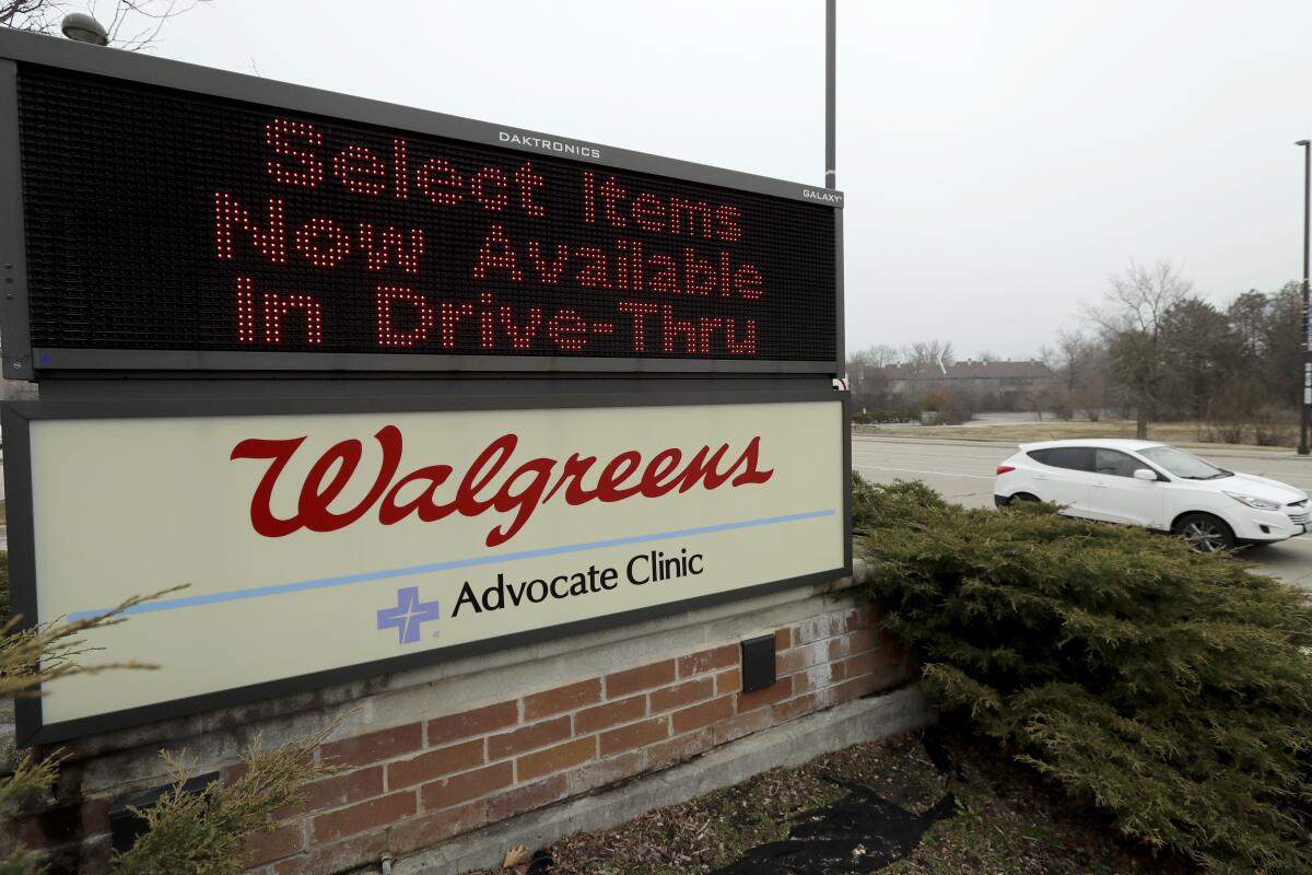 A Walgreens reader board advertises "Select items now available in drive-thru."