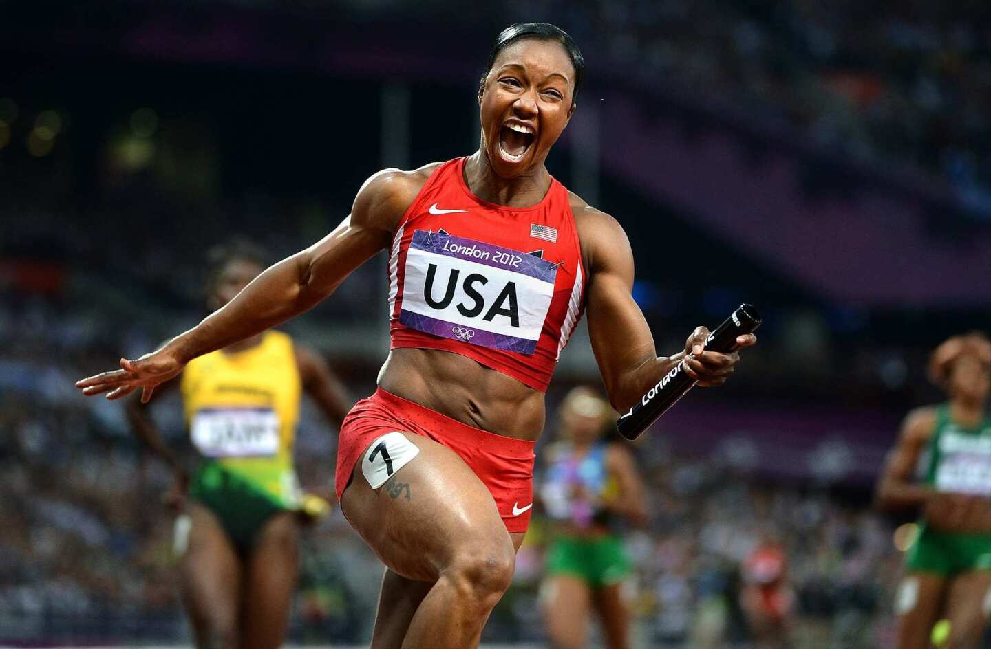 Carmelita Jeter crosses the finish line as anchor of the U.S. 4x100 relay team after it sets a world record of 40.82 seconds.