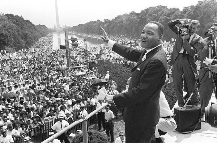 The Rev. Martin Luther King Jr., center, waves from the steps of the Lincoln Memorial to supporters on the Mall in Washington, D.C., on Aug. 28, 1963.