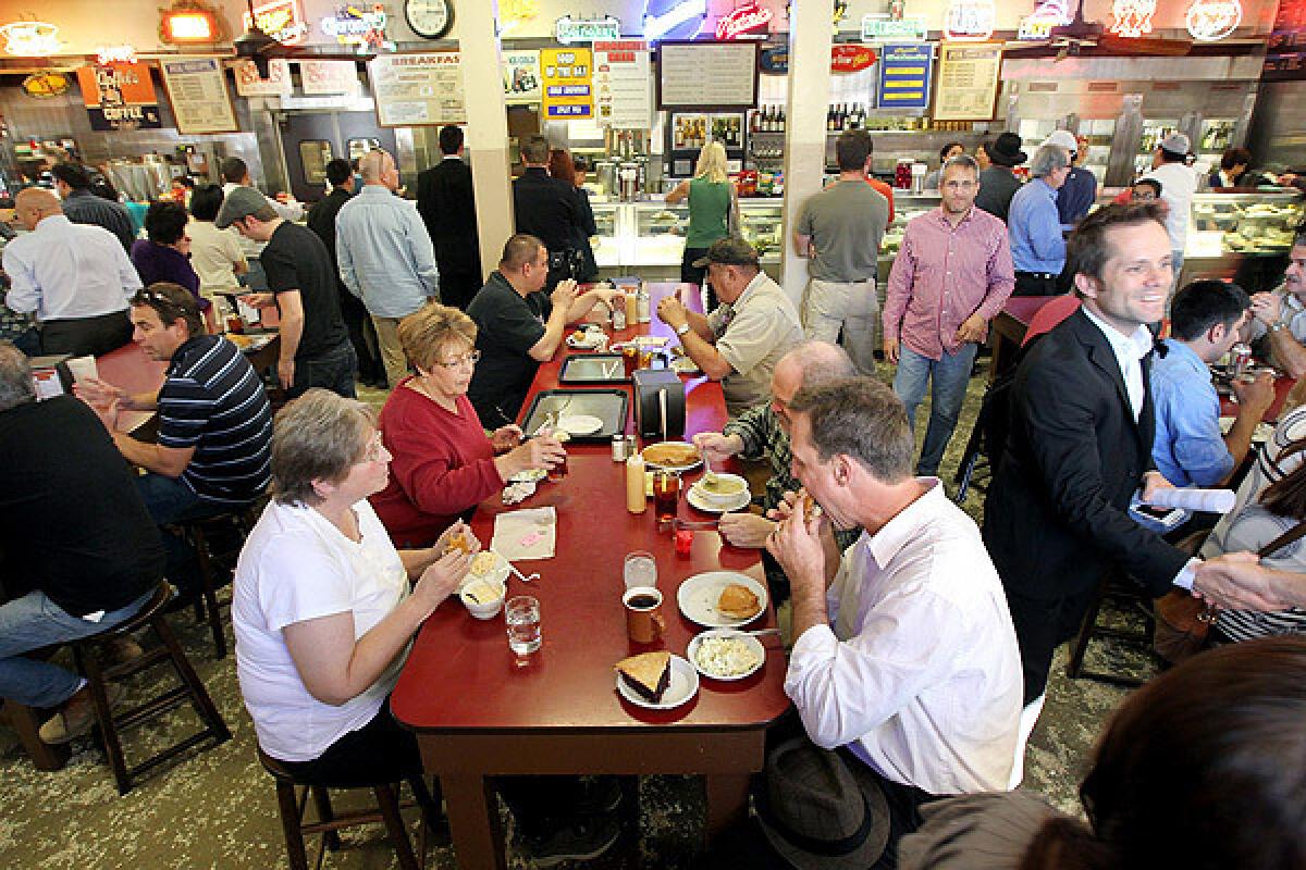 Patrons fill a dining area during lunchtime at Philippe's