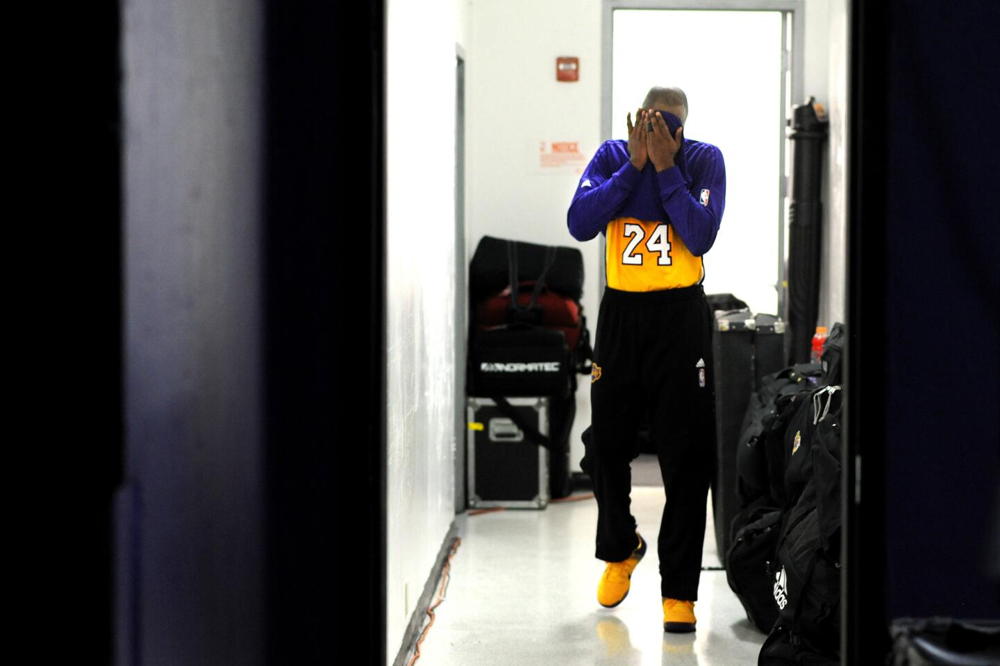 Kobe Bryant wipes his face as he leaves the Sleep Train Arena locker room at halftime during a Lakers game against the Kings in Sacramento on Jan. 7, 2016.
