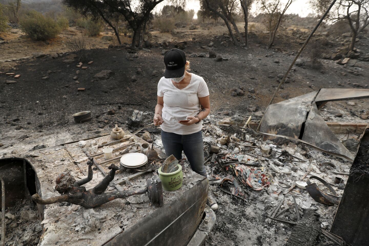 Lori Jackson, 52, looks for items that survived the fire in a mobile home park in Westlake Village.