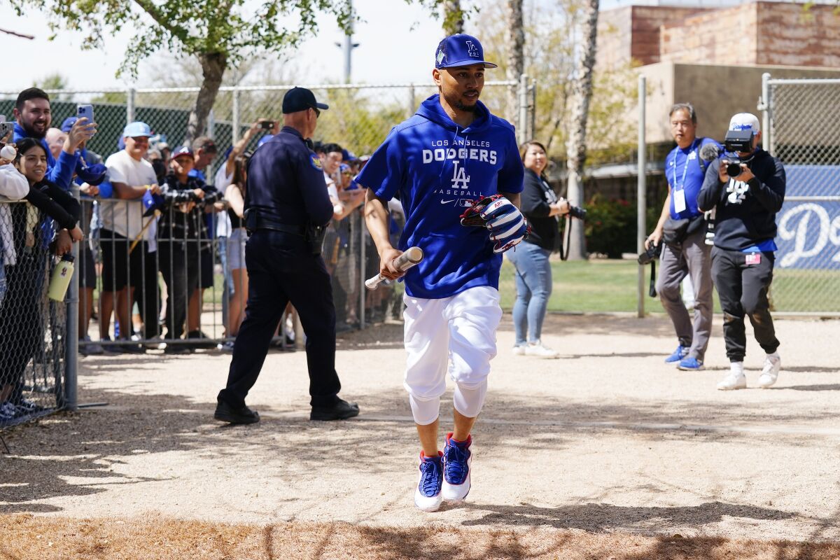Dodgers' Mookie Betts runs to a practice field during a spring training workout.