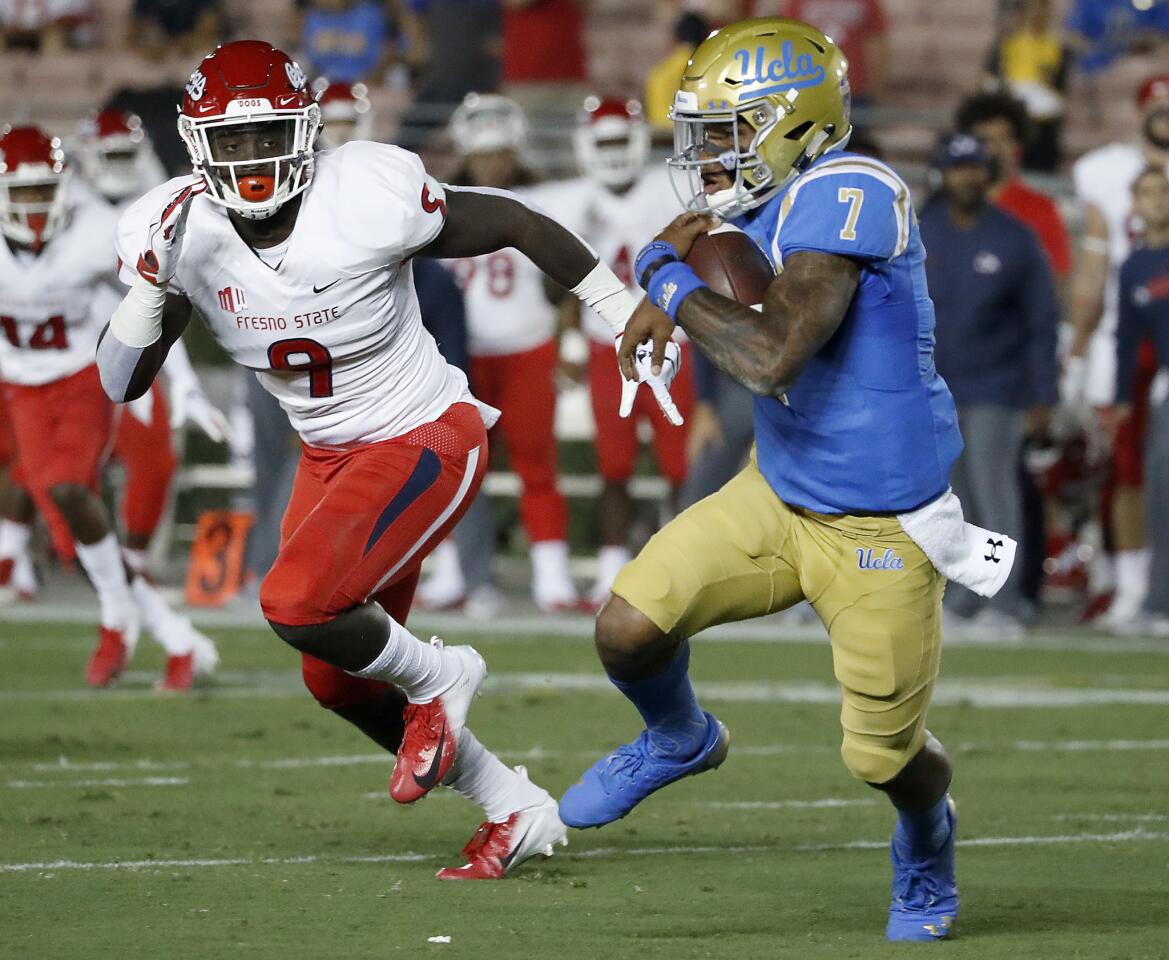 UCLA quarterback Dorian Thompson-Robinson looks for room to run as Fresno State linebacker Jeff Allison closes in during the first quarter on Saturday at the Rose Bowl.