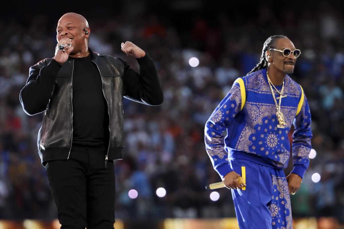 Dr. Dre in black and Snoop Dogg in a blue sweatsuit perform during halftime of the Super Bowl