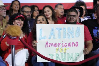 Supporters hold a sign before Trump arrives to speak in Tucson