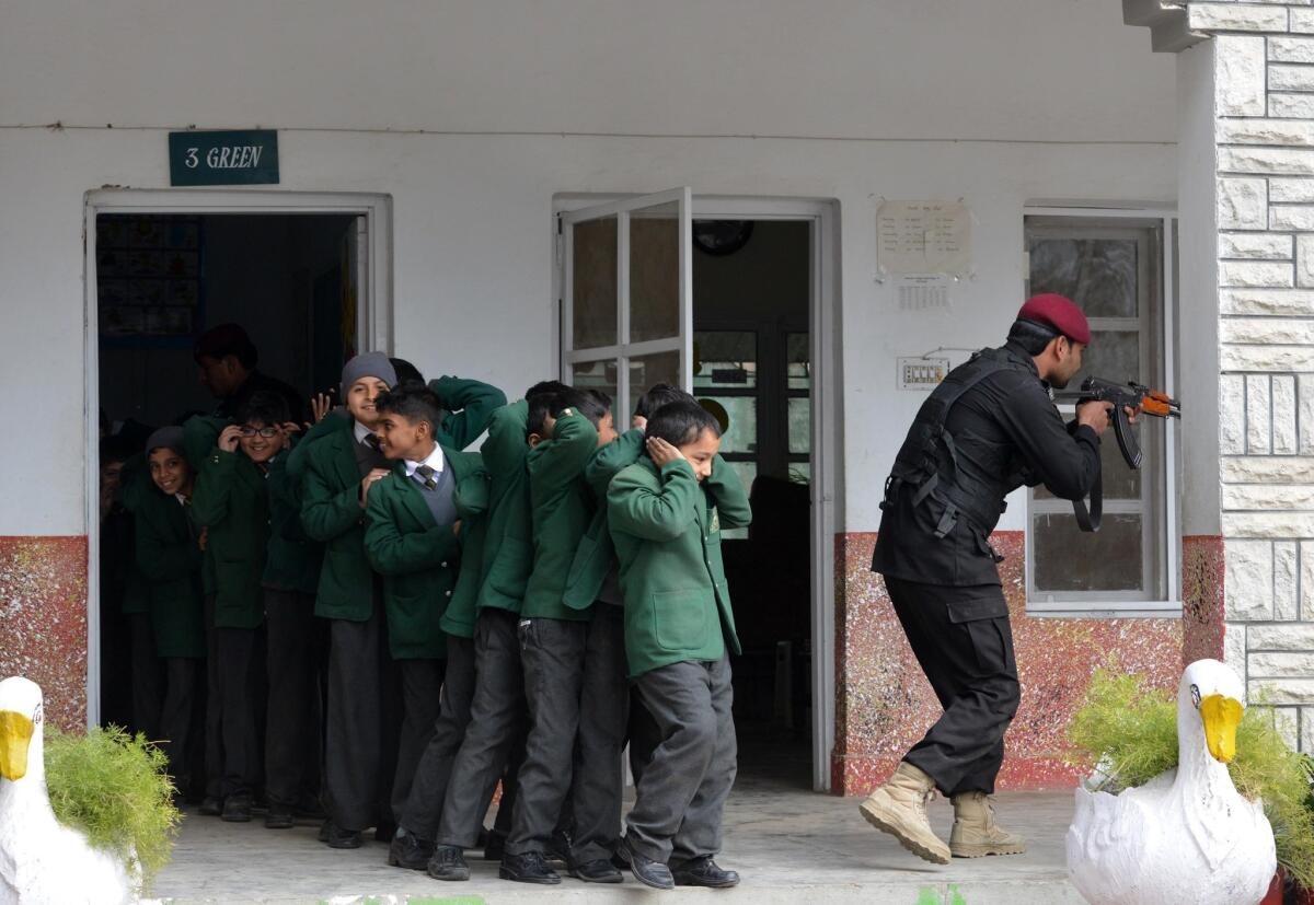 A Pakistani Elite Police Force member takes part in a drill to fight against militants at a school in Peshawar on Thursday.