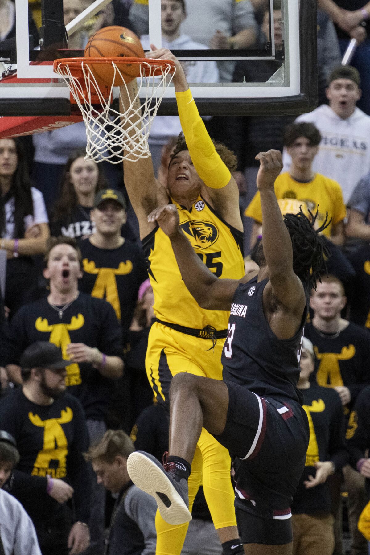 Missouri's Noah Carter, left, dunks the ball over South Carolina's Josh Gray, right, during the first half of an NCAA college basketball game Tuesday, Feb. 7, 2023, in Columbia, Mo. (AP Photo/L.G. Patterson)