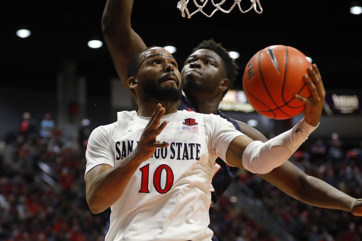 San Diego State's KJ Feagin scores in front of against Fresno State's Assane Diouf on Jan. 1, 2020.