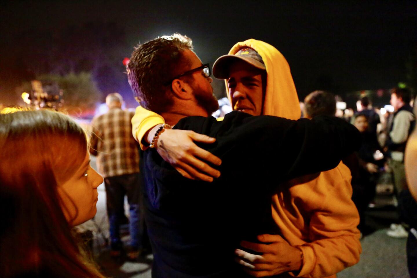 Holden Harrah, 21, right, who witnessed the shooting, hugs family and friends