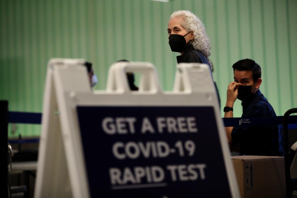 A sign in an airport terminal says Get a free COVID-19 rapid test