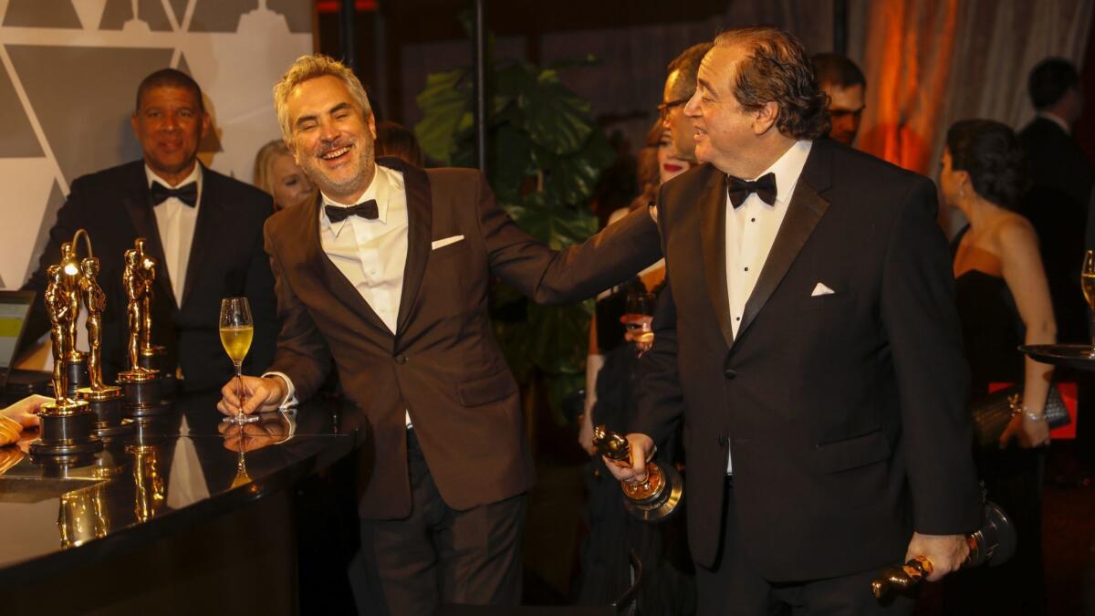 "Roma's" Alfonso Cuarón, left, shares a laugh with "Green Book's" Nick Vallelonga.