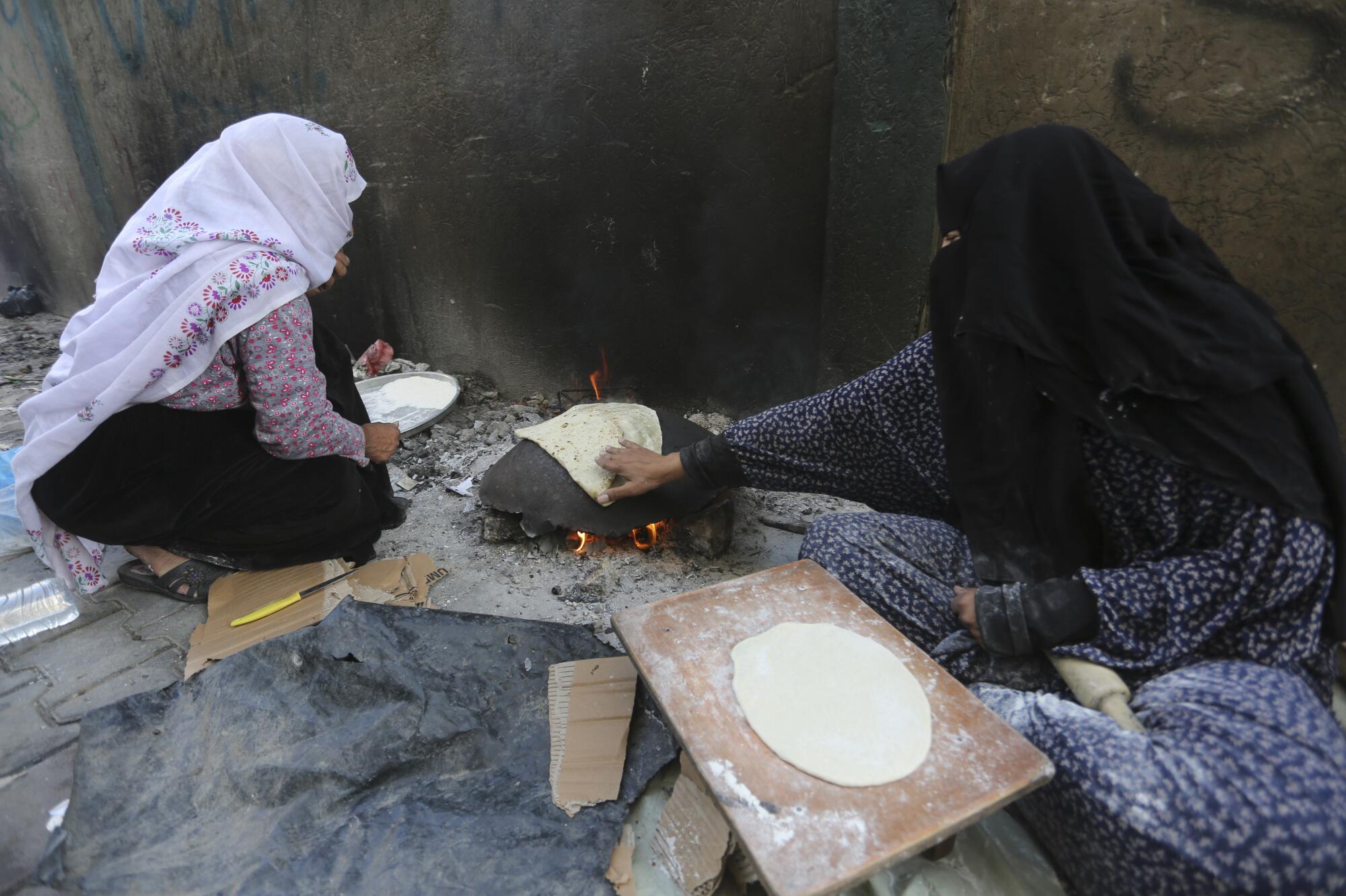 Woman baking bread outdoors in Rafah, Gaza Strip