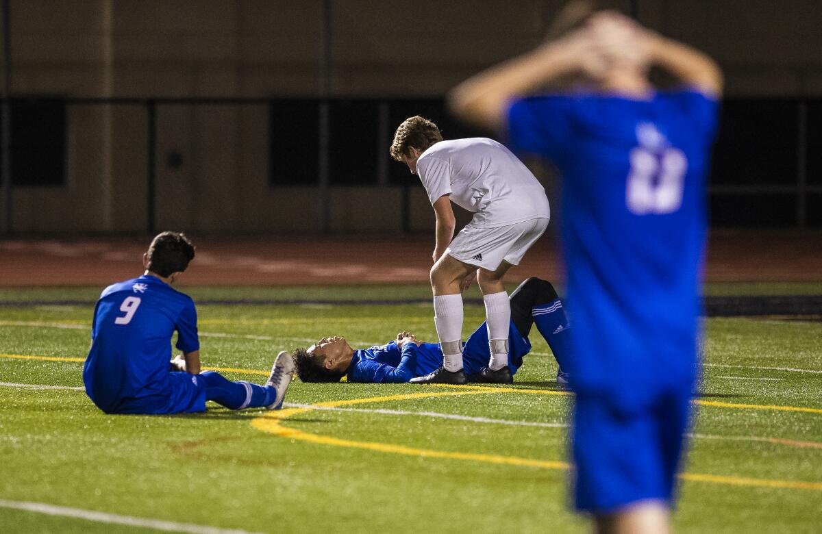 Corona del Mar's Carson Webb consoles a Los Alamitos player on the field after the Sea Kings win 1-0 in a Surf League second-place tiebreaker match on Thursday.