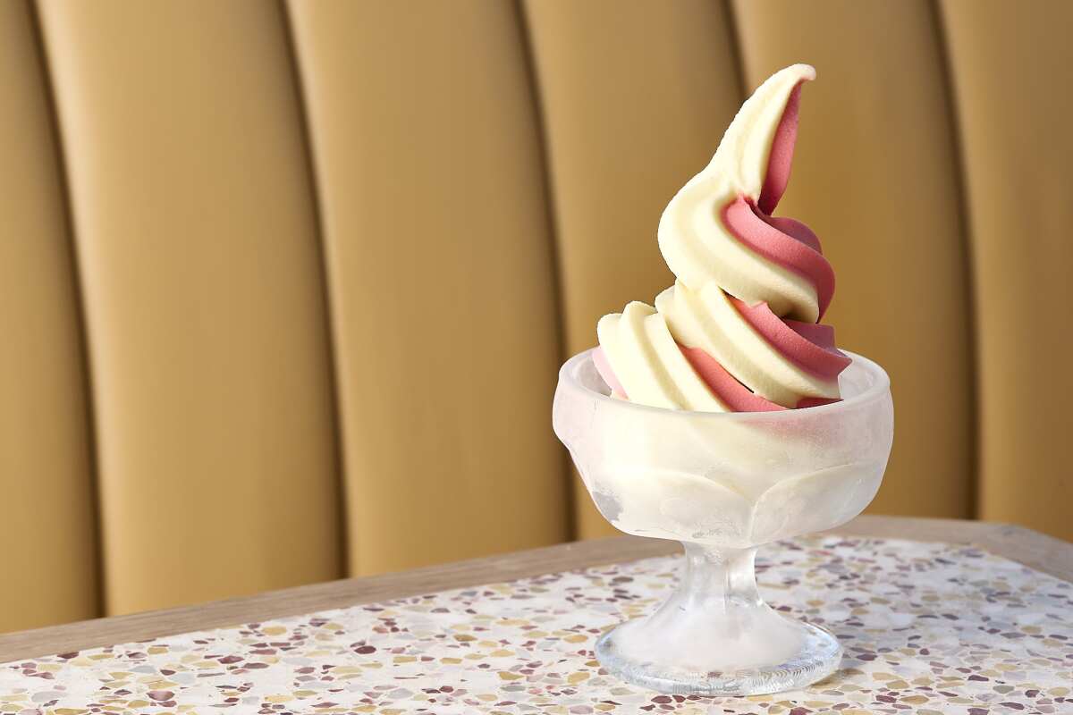 Pineapple and cherry soft serve swirl in a glass footed dish