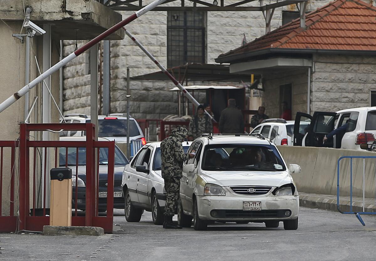 A soldier checks the passports of Syrians seeking to enter Lebanon at the Masnaa border crossing on Jan. 5.