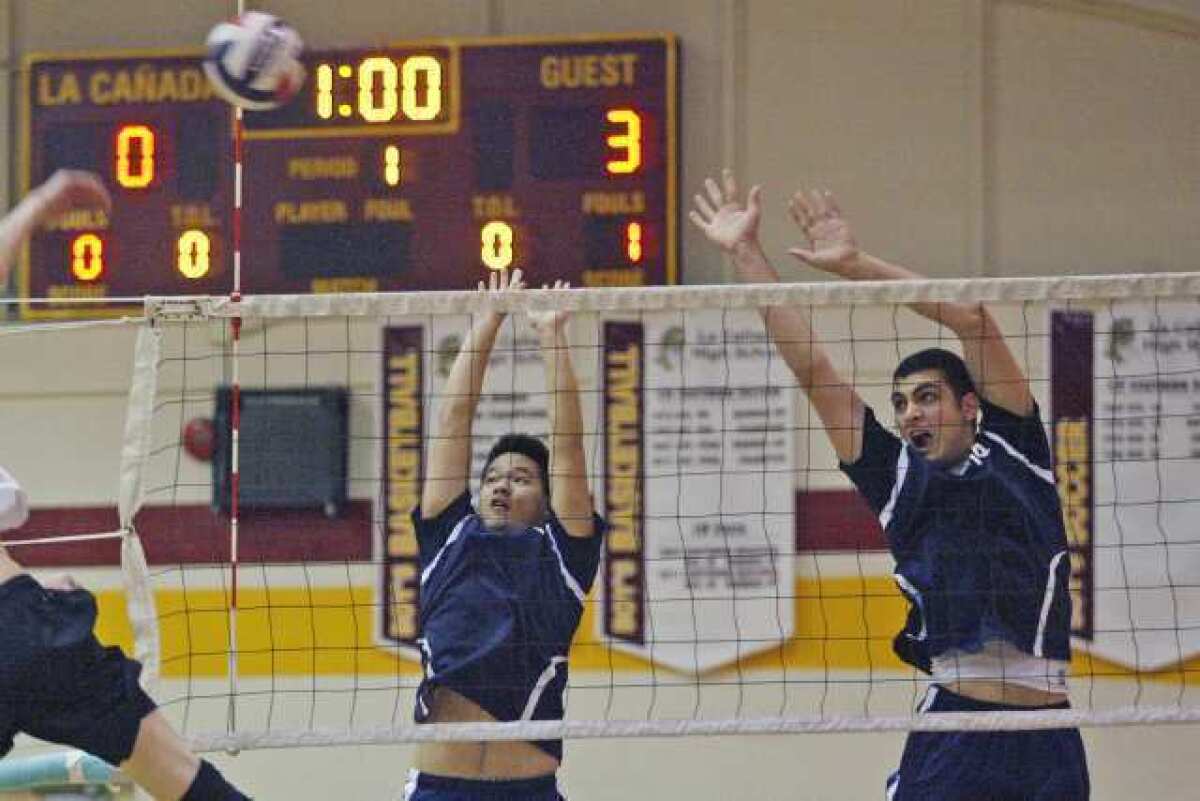 Flintridge Prep's Mike Lii, from left, and Kareem Ismail go up for a block in a match at La Cañada High.