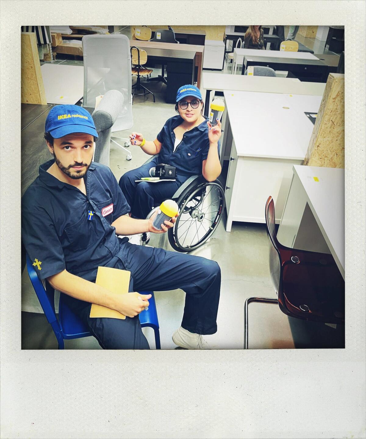 Two people in blue coveralls and blue baseball hats pose for a portrait at Ikea.