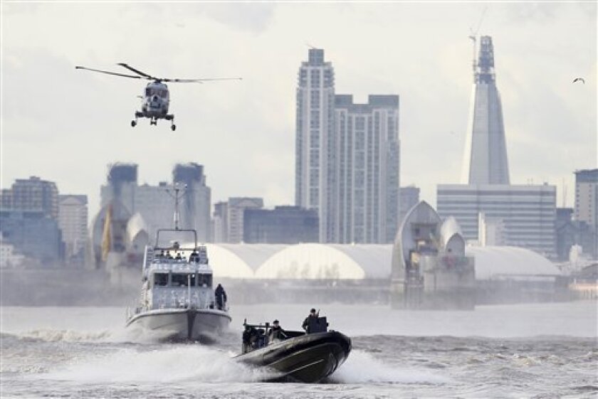 FILE - In this Thursday, Jan. 19, 2012 file photo security forces take part during in a combined British police and British Royal Marines security exercise for the London 2012 Olympic Games on the River Thames in London. Fighter jets thunder above the English countryside. Missiles stand ready. And Big Brother is watching like never before. The London Olympics are no ordinary games _and Britain is no ordinary host. Not since World War II have Britain and the United States teamed up for such a massive security operation on British soil, and not without reason. (AP Photo/Alastair Grant, File)