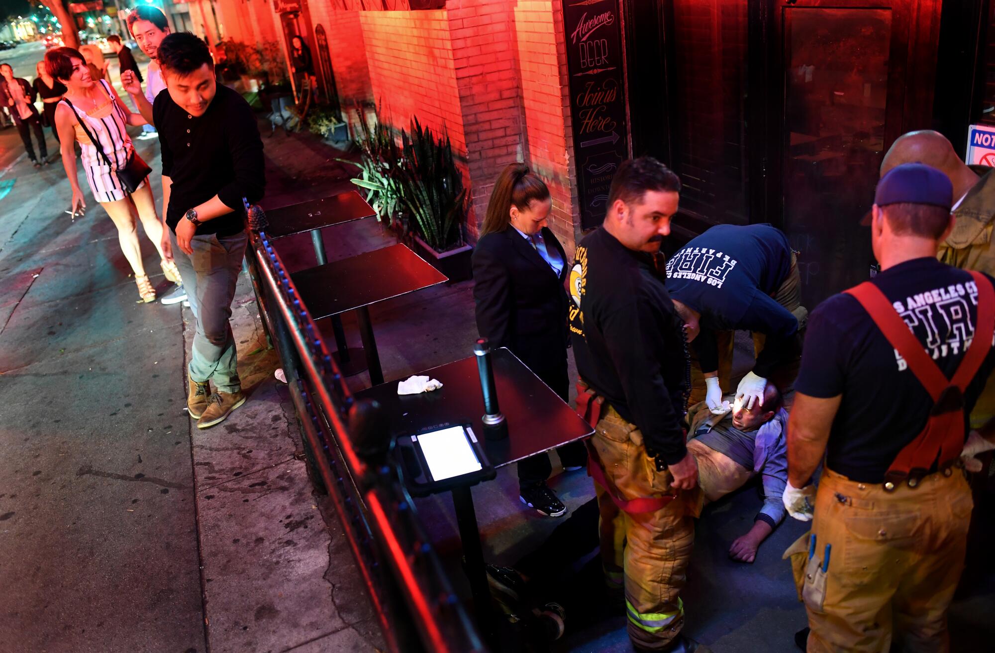 Firefighters treat an unconscious person outside Cole's French Dip in downtown Los Angeles