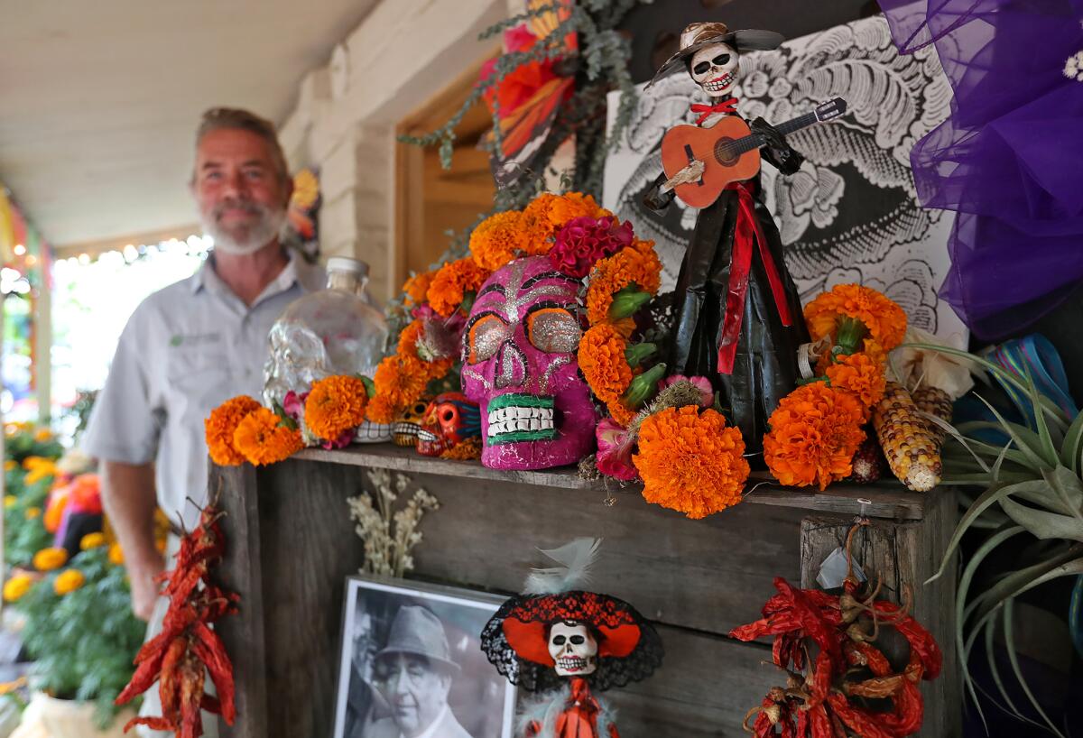 Horticulturist Tim Chadd stands next to the La Ofrenda, Dia de los Muertos altar he built at the Sherman Library & Gardens.
