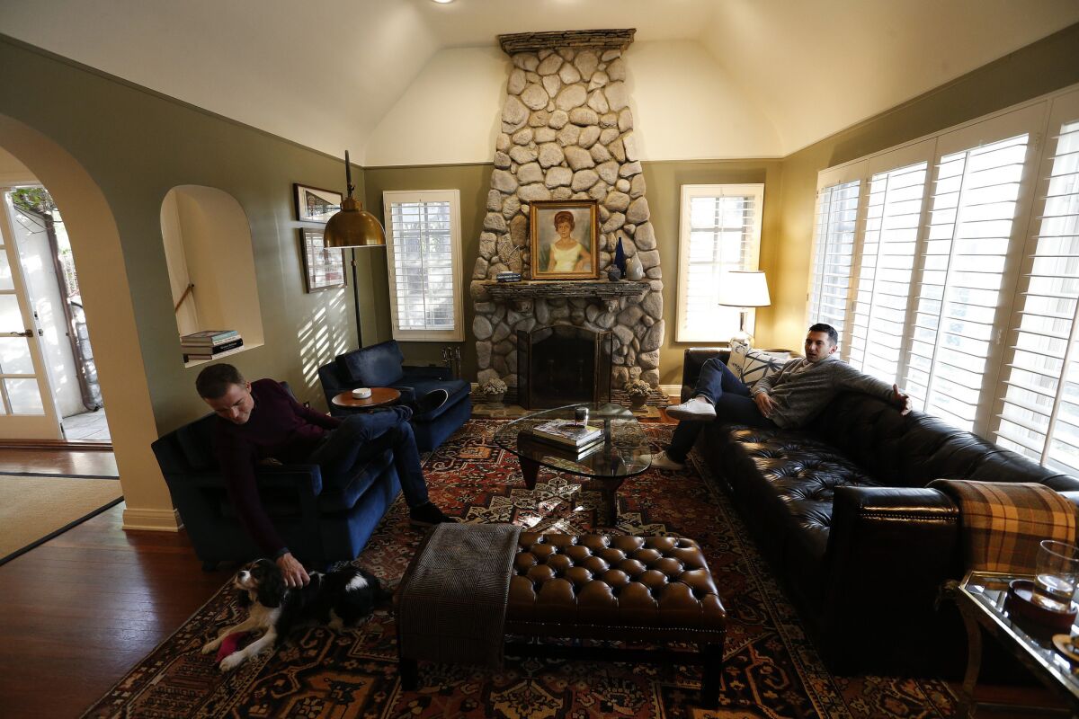 Patrick Wildnauer, left, and his husband Tom Balamaci, sit inside the living room of their English cottage style home. (Mel Melcon / Los Angeles Times)