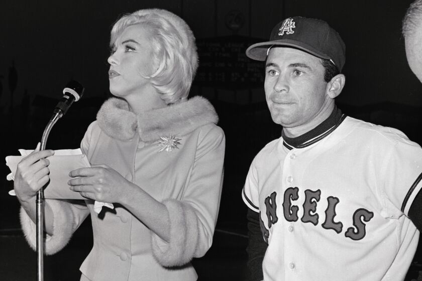 (Original Caption) Actress Marilyn Monroe runs into the field at Chavez Ravine accompanied by Los Angeles Angel