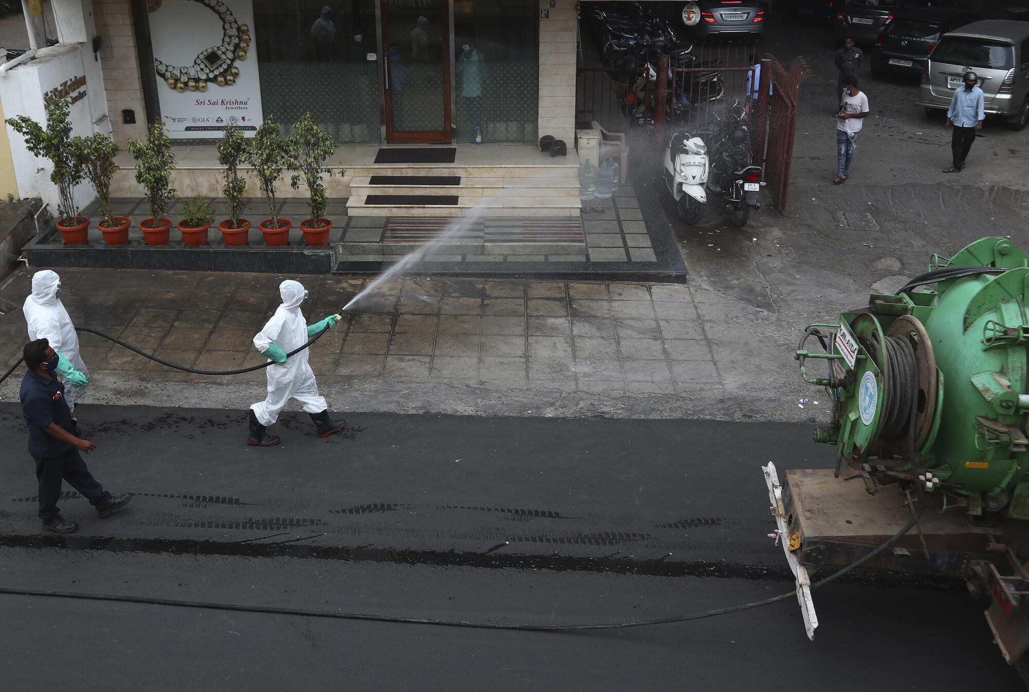 A worker sprays disinfectant.