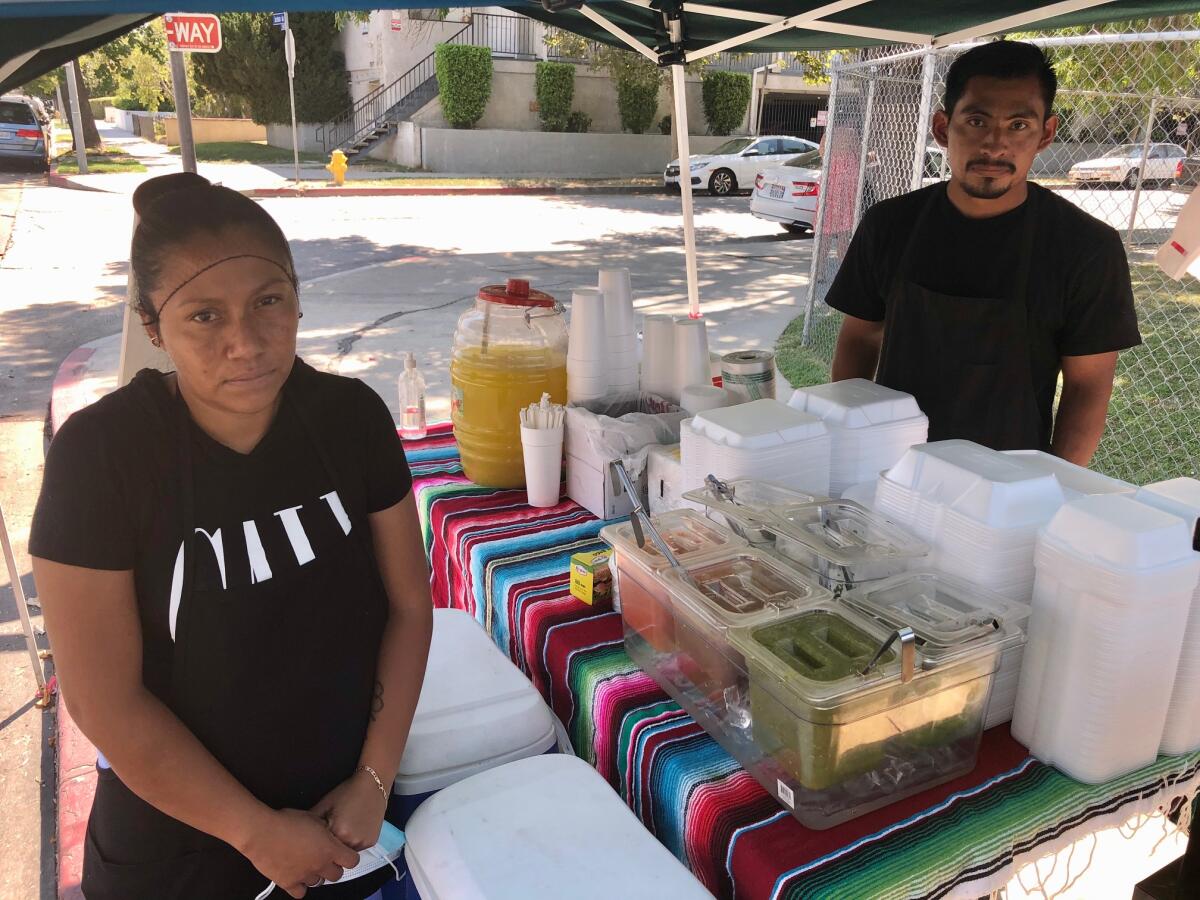 Ana Celis y Adolfo Castro colocan su venta de comida y refrescos en el 21800 Gault Street, en Canoga Park.