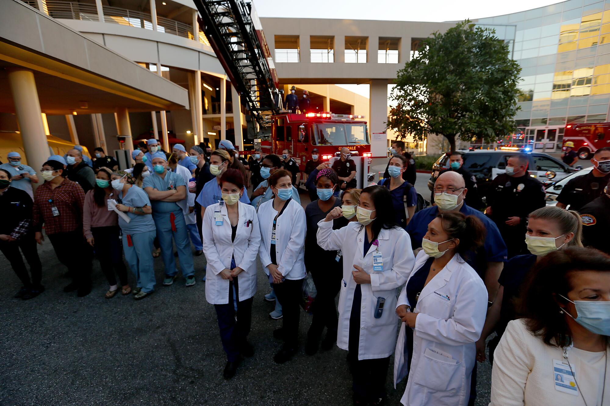 Healthcare workers, police officers and firefighters gather outside the Glendale hospital.