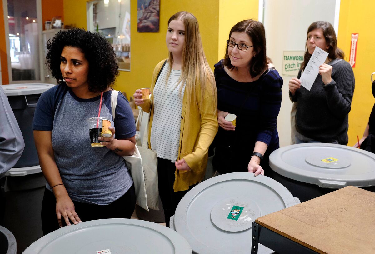 A Caffeine Crawl led by a group called The Lab toured dozens of San Diego spots over the weekend in an effort acquaint coffee lovers with local roasters and coffee shops. Caffeine Crawl participants at Ryan Bros. coffee stand next to bins of roasted coffee that they were encouraged to smell.