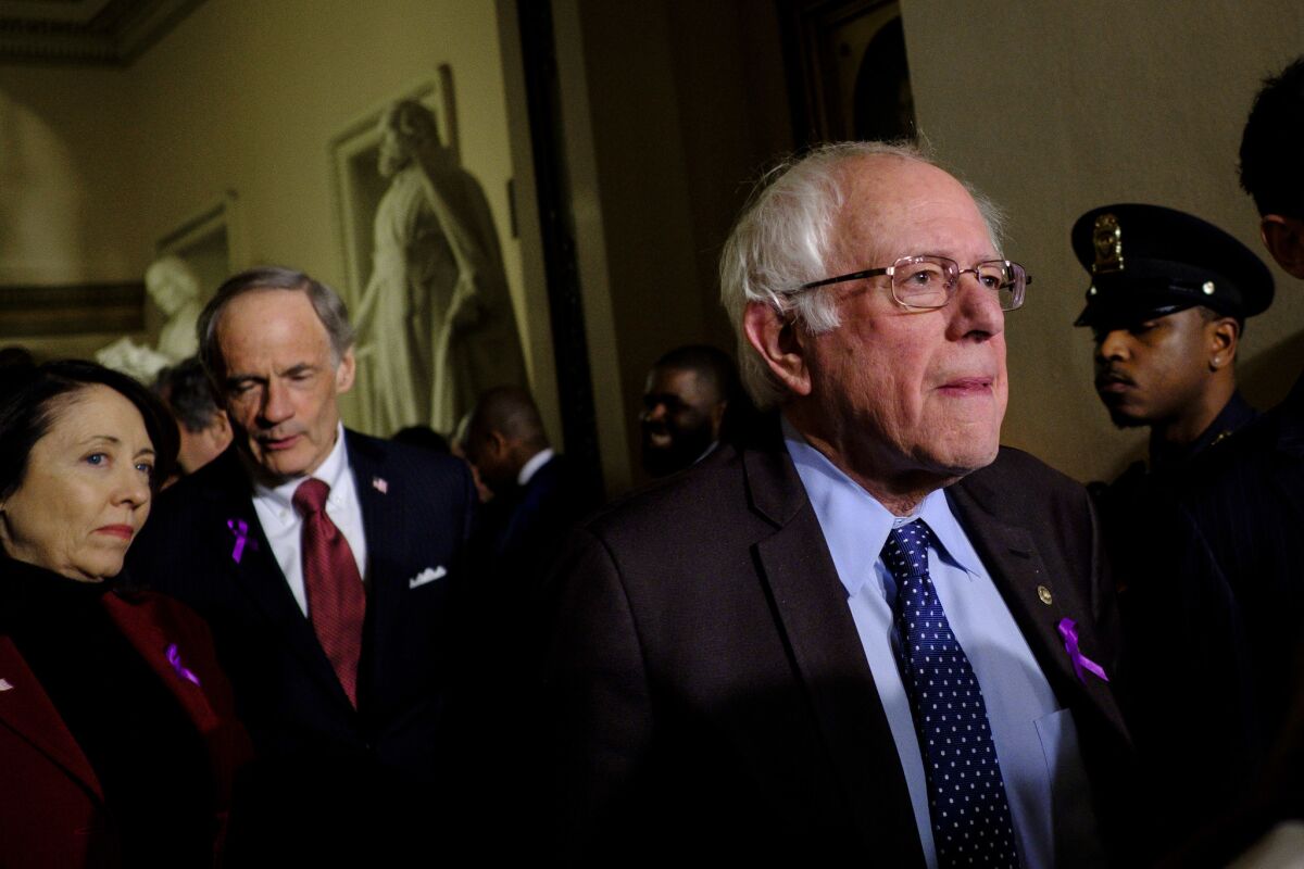 Wearing a purple awareness ribbon, Sen. Bernie Sanders, D-Vt., leaves the House of Representatives Chamber after President Trump's first State of the Union address before a joint session of Congress on Tuesday.