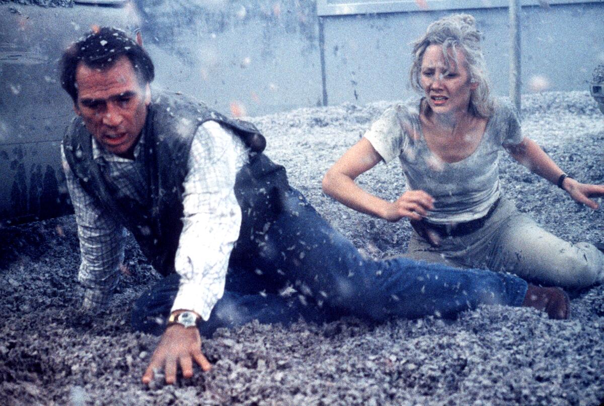 A man and woman on the ground covered in ash.