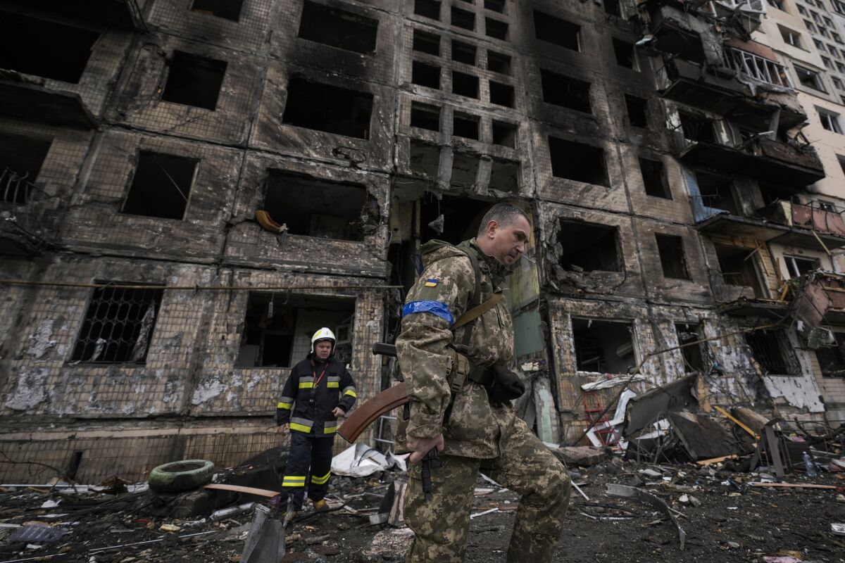 FILE - Ukrainian soldiers and firefighters search in a destroyed building after a bombing attack in Kyiv, Ukraine, Monday, March 14, 2022. (AP Photo/Vadim Ghirda, File)