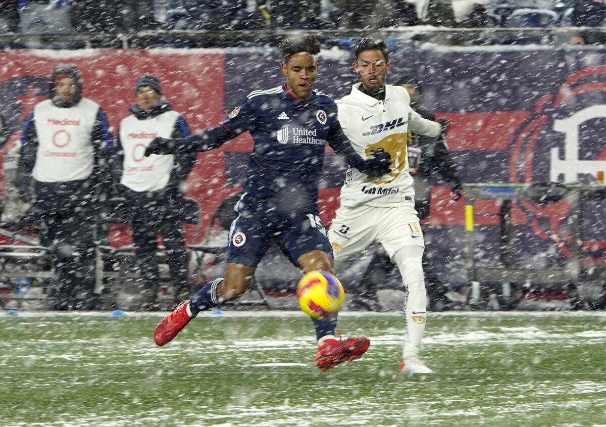 New England Revolution midfielder Brandon Bye (15) and Pumas defender Jeronimo Rodriguez (16) vie for the ball in the snow during the first half of a CONCACAF Champions League soccer match Wednesday, March 9, 2022, in Foxborough, Mass. (AP Photo/Mary Schwalm)