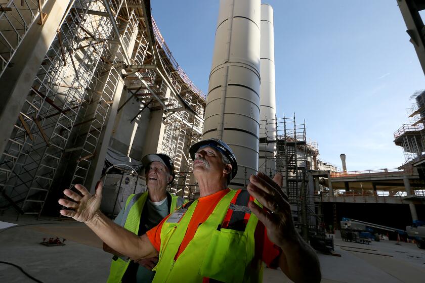 Los Angeles, CA - Larry Hart, right, a rocket booster expert with the Samuel Oschin Air and Space Center, looks at the contruction of the building that will house the Space Shuttle Endeavour at Exposition Park in Los Angeles. (Luis Sinco / Los Angeles Times)