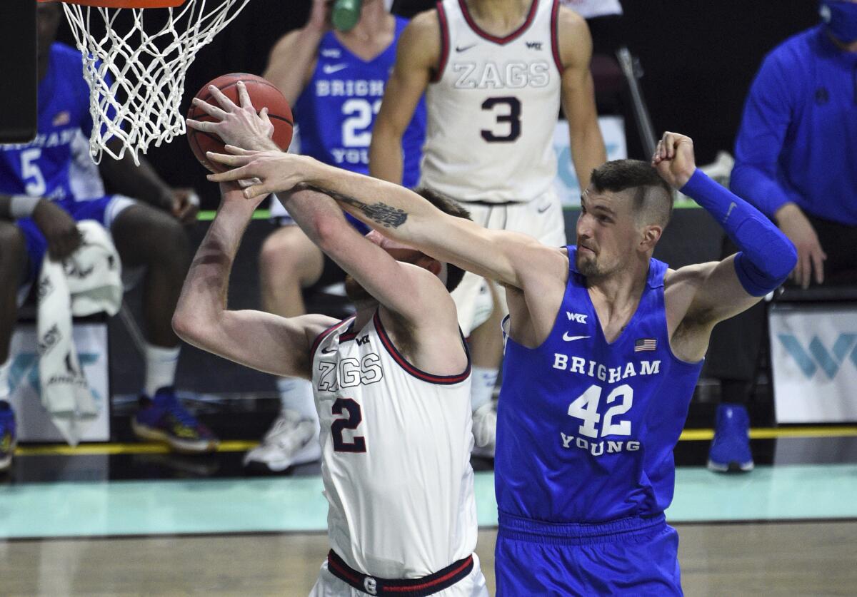 BYU center Richard Harward (42) defends against Gonzaga forward Drew Timme during the first half of an NCAA college basketball game for the West Coast Conference men's tournament championship Tuesday, March 9, 2021, in Las Vegas. (AP Photo/David Becker)