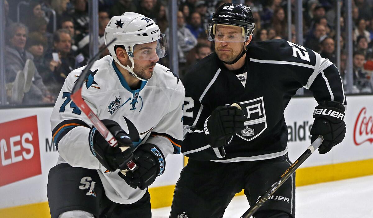 Los Angeles Kings center Trevor Lewis (22) gets ready to check San Jose Sharks defenseman Dylan DeMelo (74) in to the boards in the first period at Staples Center on Tuesday.