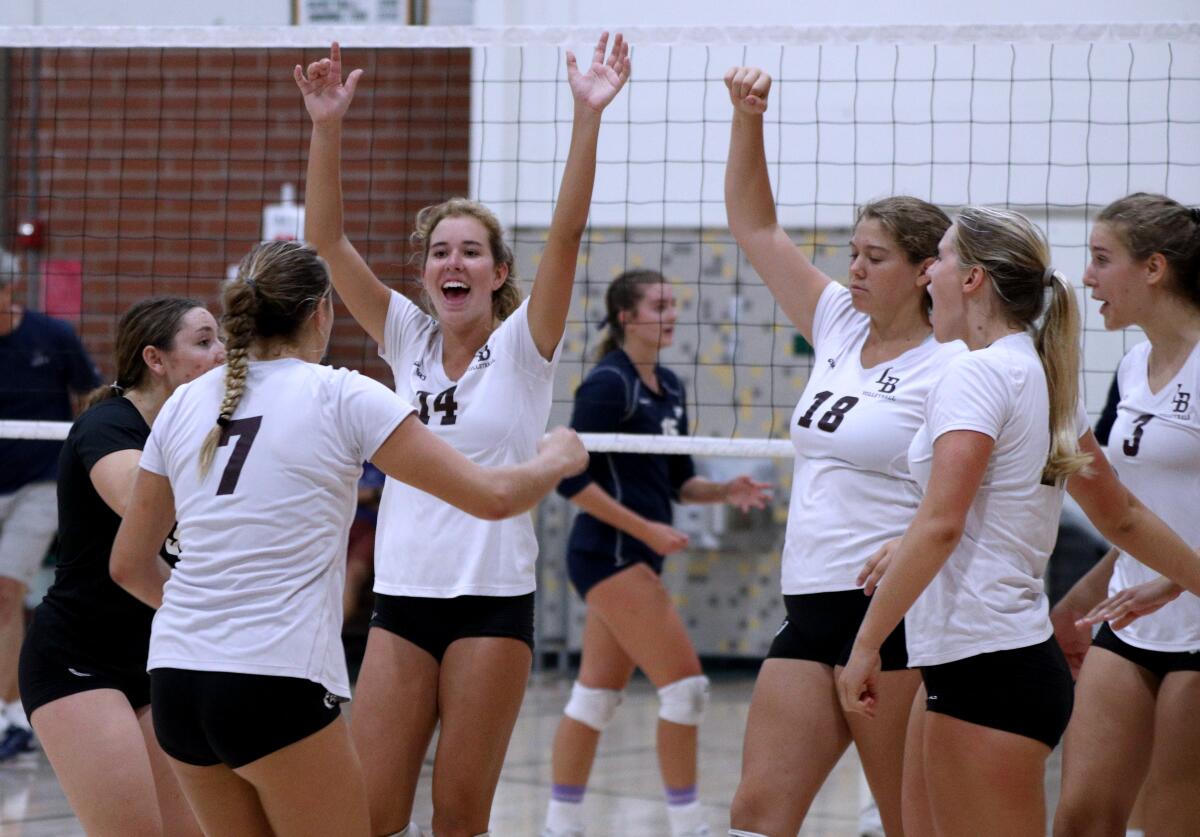 Laguna Beach's Piper Naess (14) and her teammates celebrate a point as they beat Trabuco Hills to advance to the semifinals of the Dave Mohs Memorial Tournament at Edison High on Sept. 7.