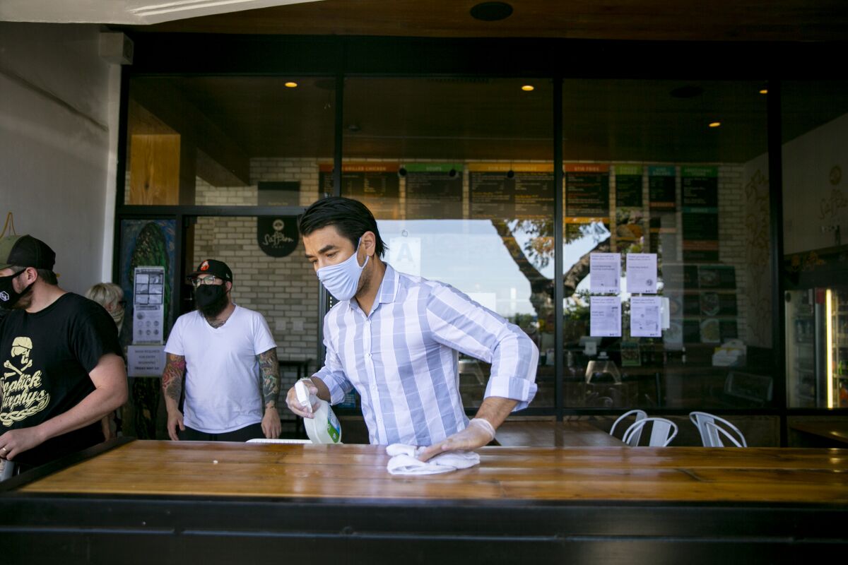 David Contreras-Curiel, the owner of Saffron Thai, wipes down a table last year.