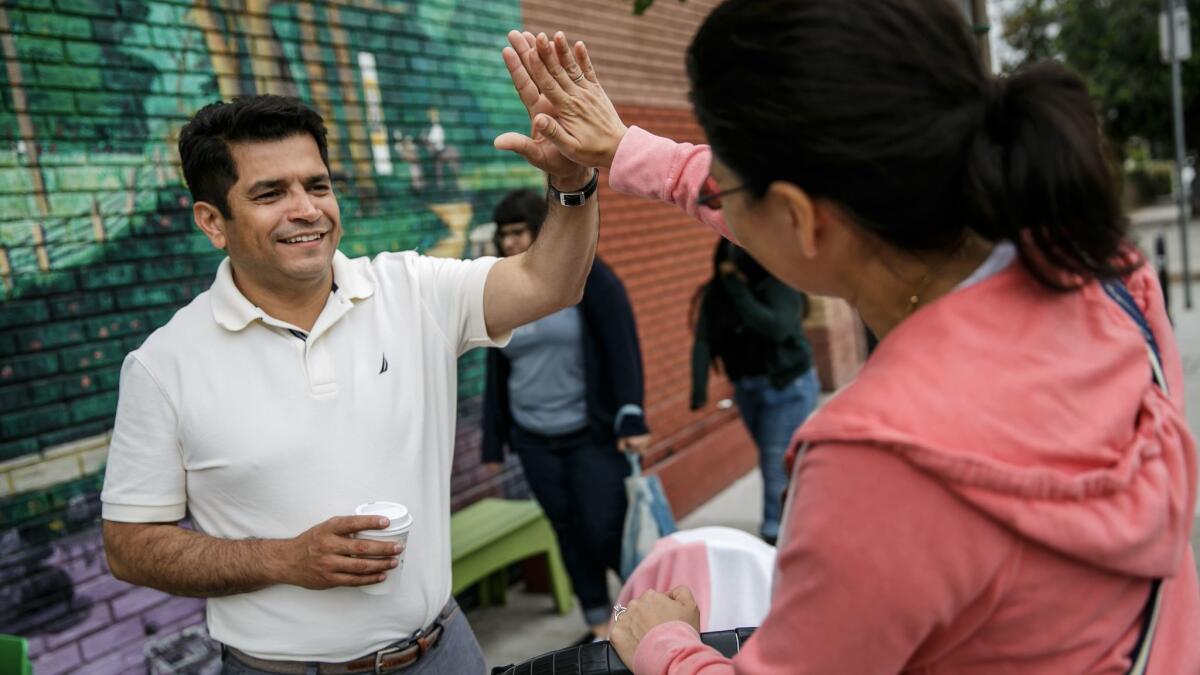 Congressman-elect Jimmy Gomez gets a high-five from former primary opponent Vanessa Aramayo the day after winning the election to represent the 34th Congressional District.