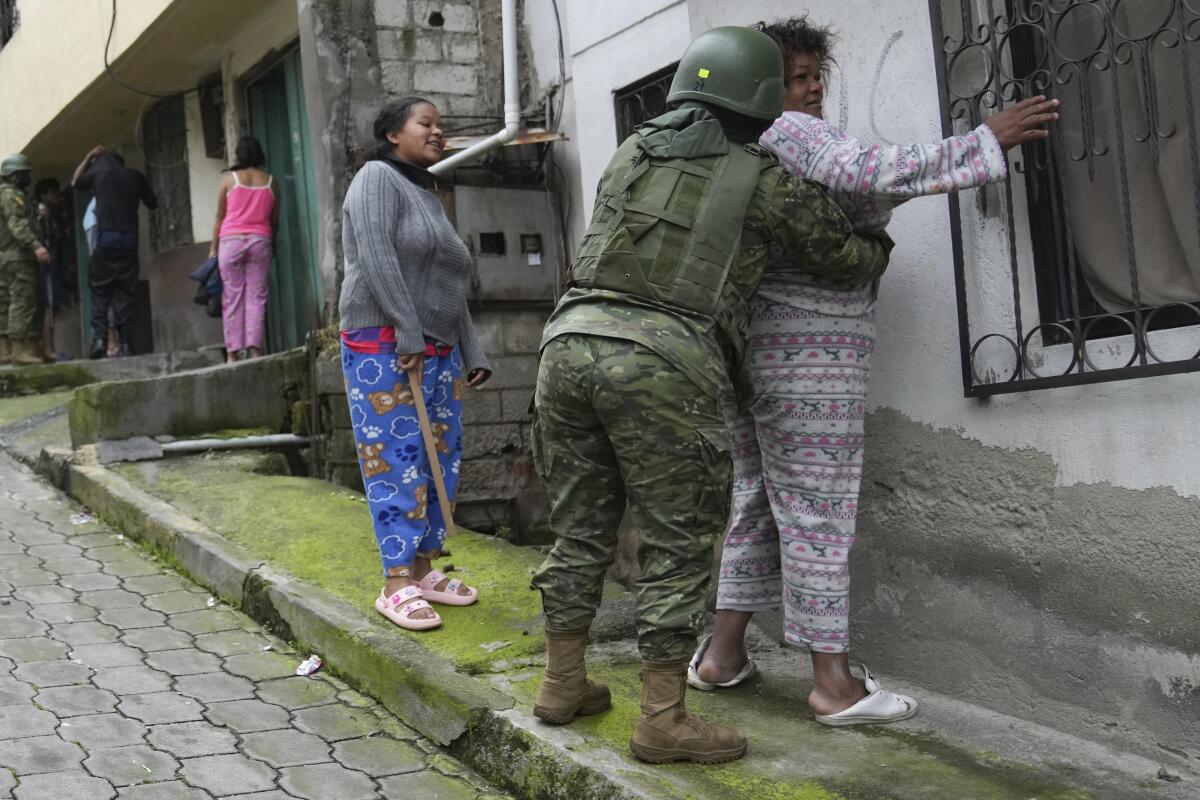 Soldiers search women as they patrol the south side of Quito, Ecuador, Friday, Jan. 12, 2024, in the wake of the apparent escape of a powerful gang leader from prison. President Daniel Noboa decreed Monday a national state of emergency, a measure that lets authorities suspend people’s rights and mobilize the military in places like the prisons. The government also imposed a curfew from 11 p.m. to 5 a.m. (AP Photo/Dolores Ochoa)