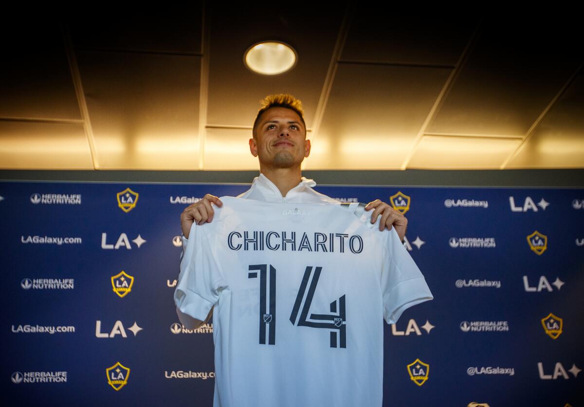Galaxy star Javier 'Chicharito' Hernández shows off his jersey during his introductory news conference Thursday.
