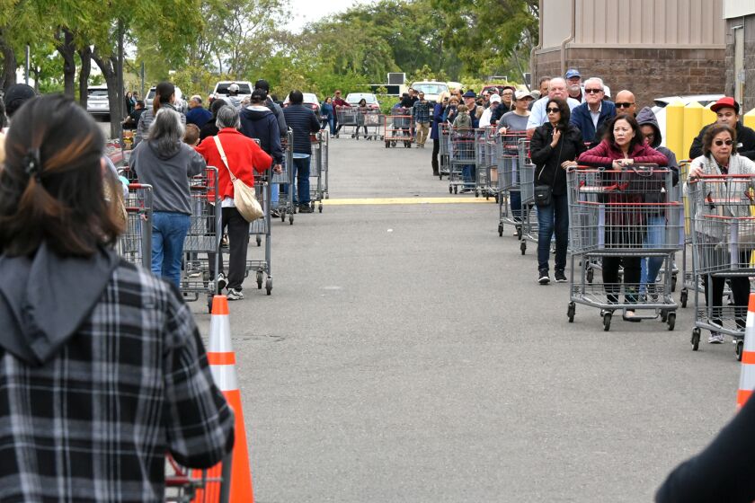 Customers lined up Monday morning outside the Costco store in Poway. Grocery stores were reporting huge sales of paper towels, toilet paper and other items as the public worries about the impact of COVID-19 health directives.