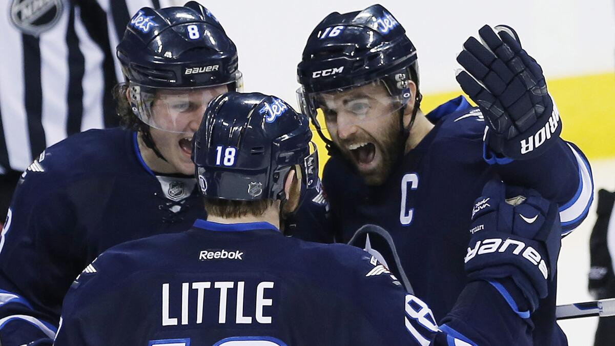 Winnipeg Jets captain Andrew Ladd, right, celebrates with teammates Jacob Trouba, left, and Bryan Little after scoring during a 6-2 win over the Colorado Avalanche on Friday.