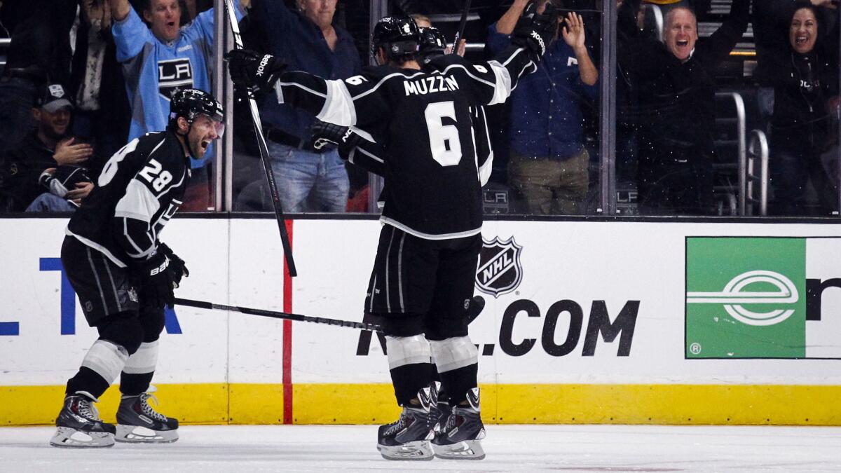 Kings center Jarret Stoll, left, celebrates with teammate Jake Muzzin after scoring in overtime to lift the Kings to a 3-2 win over the Ducks on Saturday.