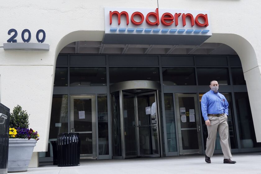 FILE - A man stands outside an entrance to a Moderna, Inc., building, Monday, May 18, 2020, in Cambridge, Mass. A second COVID-19 vaccine moved closer to joining the U.S. fight against the pandemic Thursday, Dec. 17, 2020 as government experts convened for a final public review of its safety and effectiveness. The shot from Moderna and the National Institutes of Health is urgently needed as the country continues to record ever-higher numbers of new cases, hospitalizations and deaths ahead of more holiday travel and family gatherings. FDA's OK is expected shortly after the all-day meeting concludes. (AP Photo/Bill Sikes, file)