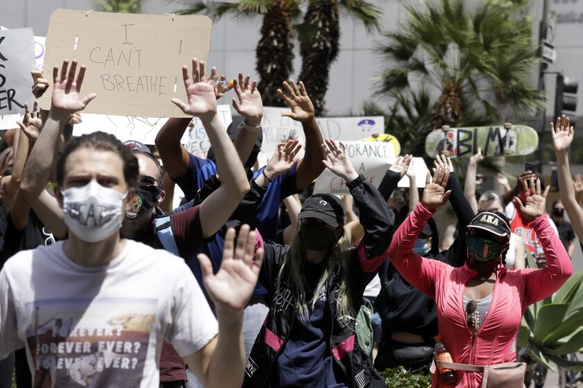 LOS ANGELES, CA - MAY 31: Protesters raise their arms chanting "Hands up, don't shoot!" during a protest at Pershing Square in downtown Los Angeles on Sunday, May 31, 2020 in Los Angeles, CA. About 400 protesters took part to draw attention to the death of George Floyd and Black Lives Matter. (Myung J. Chun / Los Angeles Times)